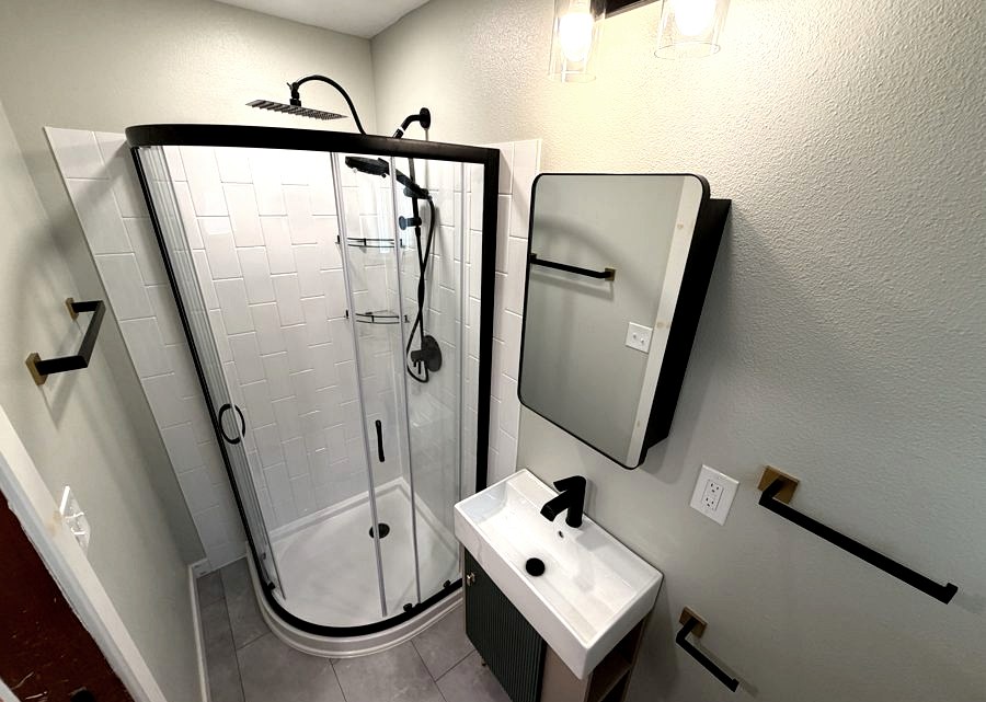 Compact full bath, Round-profile shower · maximized footprint by DA Interior Solutions