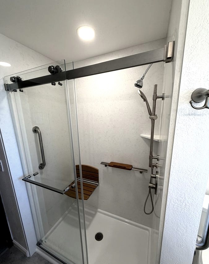 Shower renovation, Teak bench · brushed hardware · large-format tile by DA Interior Solutions