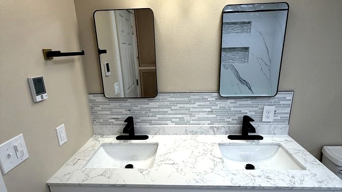 Double vanity, Stone top · sconce lighting · custom storage by DA Interior Solutions